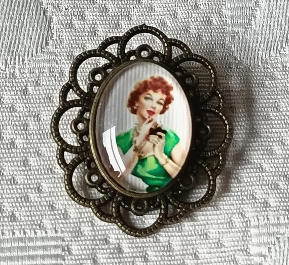 Vintage metal brooch with pin-up cabochon