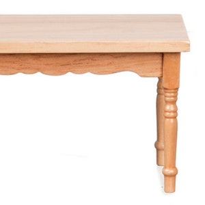 Puede incluir: Pequeña mesa de madera clara con tapa rectangular y borde festoneado decorativo. La mesa tiene cuatro patas torneadas, cada una de aproximadamente 3,8 cm de diámetro, y es adecuada para casas de muñecas o escenarios en miniatura.