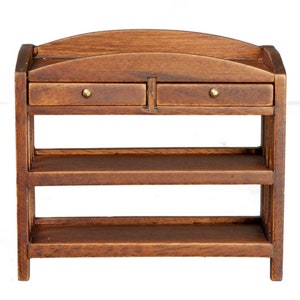 May include: A miniature wooden cabinet with two small drawers and two shelves. The cabinet is made of dark brown wood and has brass knobs on the drawers. The top of the cabinet has a curved design.