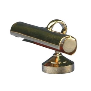 May include: A miniature gold-colored desk lamp with a curved handle. The lamp has a cylindrical body and a round base. The lamp's design is simple and elegant, with a focus on the metallic finish.