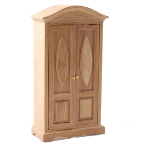 May include: A wooden dollhouse-sized armoire with two doors and a carved design on the top. The doors have oval-shaped panels and gold-colored knobs.