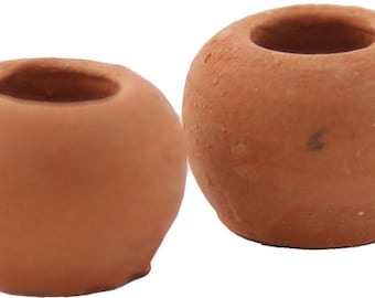 Könnte beinhalten: Zwei kleine, runde Kerzenhalter in Terrakotta-Farbe. Jeder hat eine kreisförmige Öffnung oben und eine glatte, unglasierte Oberfläche. Die Kerzenhalter sind ideal für kleine Kerzen oder Teelichter und verleihen jeder Einrichtung einen rustikalen Touch.