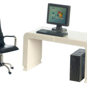 May include: A white computer desk with a black computer monitor, keyboard, and tower. A black office chair with a swivel base and wheels is next to the desk.
