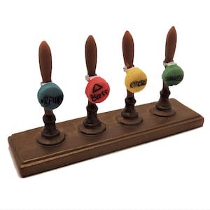 May include: Four wooden beer taps with colorful plastic tops. The tops are labeled "VRPHKS", "Bass", "KITCHENER", and "ZOMBIES".