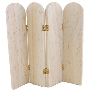 Peut inclure: Un séparateur de pièce en bois à quatre panneaux avec des charnières dorées. Le séparateur est en bois clair et a une finition naturelle.