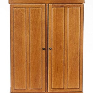 May include: A wooden two-door cabinet with a simple design. The cabinet has a light brown finish and a decorative base.