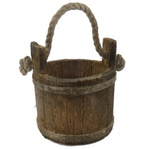 May include: A small wooden bucket with a rope handle. The bucket is brown and has a natural wood finish.