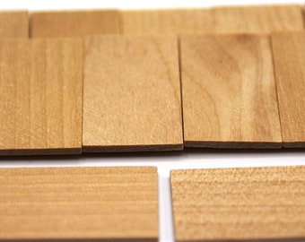 May include: A set of small, unfinished wooden squares. The squares are arranged in rows and are all the same size. The wood is a light brown color and has a natural grain.