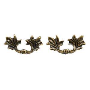 May include: Two antique-style drawer pulls with a bronze finish. Each pull features a curved design with leaf-shaped details, adding a vintage touch. These decorative hardware pieces are ideal for cabinets and drawers.