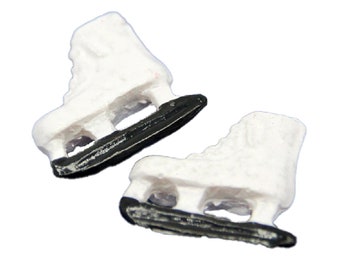 Puede incluir: Dos patines de hielo en miniatura blancos con cuchillas negras. Los patines están hechos de un material blanco liso y tienen un diseño clásico de patines de hielo.