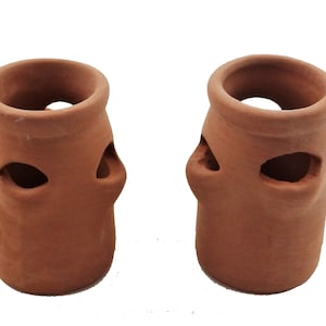 May include: Two terracotta pots with decorative cutouts. The pots are brown and have a rustic look.