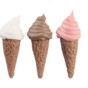 May include: Three miniature ice cream cones, one white, one brown, and one pink.