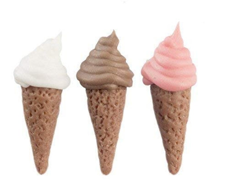 May include: Three miniature ice cream cones, one white, one brown, and one pink.