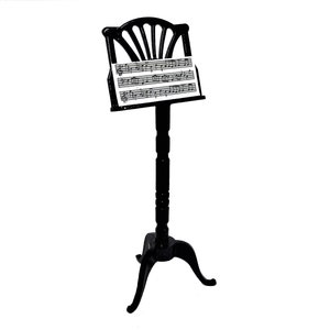 Peut inclure: Un pupitre de musique en bois noir avec une feuille de musique dessus. Le pupitre a un dessus décoratif et trois pieds.