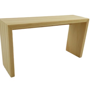 May include: A light wood console table with a simple, modern design. The table has a rectangular top and a U-shaped base.
