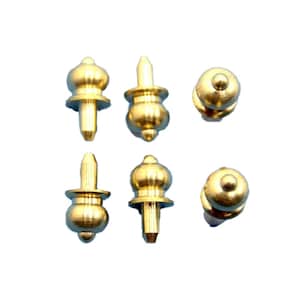 May include: Six gold-toned metal furniture tacks with a round top and a pointed bottom. The tacks have a decorative design on the top.