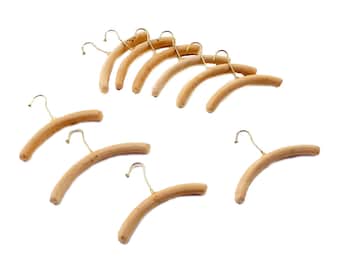 Könnte beinhalten: Ein Satz mit zehn Kleiderbügeln aus Holz mit goldenen Haken. Die Kleiderbügel sind alle gleich groß und haben die gleiche Form und sind in einem Kreis angeordnet.