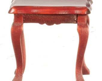 May include: A small, wooden table with a reddish-brown finish. The table has a rectangular top and four curved legs.