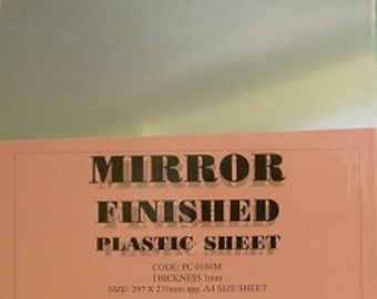 May include: A sheet of silver mirror-backed plastic, suitable for dollhouse windows, mirrors, and hobby applications. The sheet is 297 x 210 mm, or approximately A4 size. The text on the sheet reads "Mirror Finished Plastic Sheet, Code: PC0100M, Thickness 1mm, Size: 297 x 210mm app. A4 Size Sheet, Suitable for dollhouse windows, mirrors, and most hobby applications. Material: Silver mirror backed plastic. Please note: Remove the plastic protective sheet which is on both sides, which stops the plastic sheet from getting damaged or scratched."