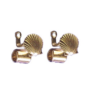 May include: Two gold-toned metal curtain tiebacks with a seashell design. Each tieback features a cylindrical tube with a decorative seashell attached to the top.