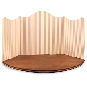 May include: A curved, wooden stage with a backdrop of yellow and pink striped paper. The stage is perfect for dollhouses or miniature scenes.