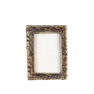 May include: A small, ornate gold picture frame with a white background. The frame has a detailed, decorative design.