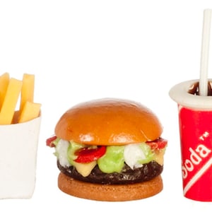 Może przedstawiać: Miniaturowy zestaw zabawek z plastiku, składający się z hamburgera, frytek i czerwono-białego kubka z sodą ze słomką. Hamburger ma bułkę z sezamem, sałatę, pomidora i kotlet. Frytki znajdują się w białym papierowym pojemniku. Na kubku z sodą widnieje napis "Soda".