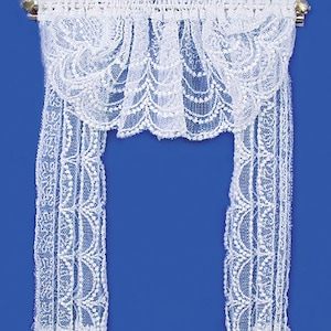 Puede incluir: Cortinas de encaje blanco con una cenefa festoneada. Las cortinas tienen un delicado patrón floral y son perfectas para añadir un toque de elegancia a cualquier habitación.