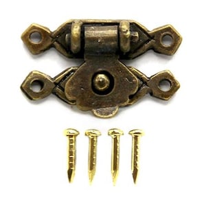 Puede incluir: Pestillo de latón antiguo con un diseño decorativo y dos pequeños tornillos de latón.