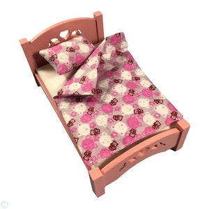 Puede incluir: Una cama de madera rosa para muñecas con un juego de ropa de cama de estampado de osos blanco y rosa. La cama tiene un recorte en forma de corazón en la cabecera.