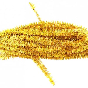 Puede incluir: Un rollo de guirnalda de lamé dorado, un adorno decorativo para árboles de Navidad y otras manualidades navideñas.