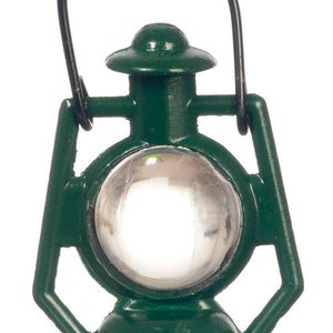 May include: A small green metal lantern with a clear glass window and a black metal handle.