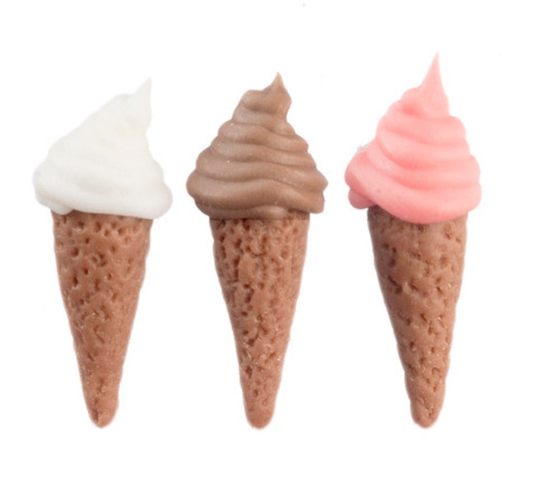 May include: Three miniature ice cream cones, one white, one brown, and one pink.