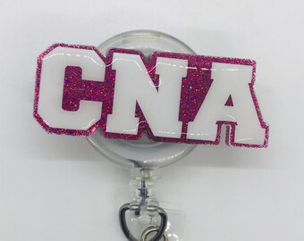 May include: A pink glitter badge reel with a white "CNA" in a white outline. The reel has a clear plastic case and a retractable cord.