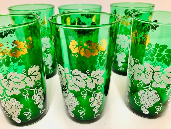 Bicchieri verdi vintage con foglie bianche e grappoli d'uva, bordo