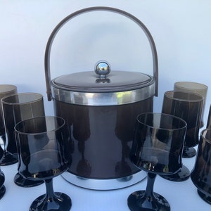 May include: A set of brown and black glass tumblers and a brown ice bucket with a silver lid and handle.