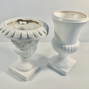Może przedstawiać: Zestaw trzech ceramicznych kubków z nakrapianym, matowym wykończeniem. Kubki są w odcieniach kremowym, jasnoszarym i ciemnoszarym. Każdy kubek ma prosty, minimalistyczny design i zaokrąglony uchwyt.