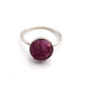 May include: A silver ring with a round, pink, and purple gemstone.