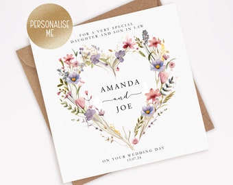 Puede incluir: Una tarjeta de boda blanca con un diseño de corazón floral. La tarjeta dice "Para una hija y un hijo muy especiales" y "Amanda y Joe" con la fecha "13.07.24" y "En el día de su boda".