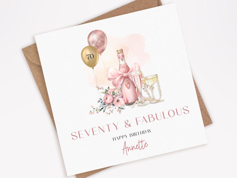 May include: A birthday card with a champagne bottle, two glasses, and balloons. The card reads "SEVENTY & FABULOUS" and "HAPPY BIRTHDAY Annette". The design includes pink flowers and a pink bow.