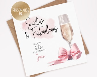 May include: A pink and white birthday card with the text "Sixty & Fabulous" and "Happy 60th Birthday Joan". A glass of champagne with a pink bow is illustrated on the card.