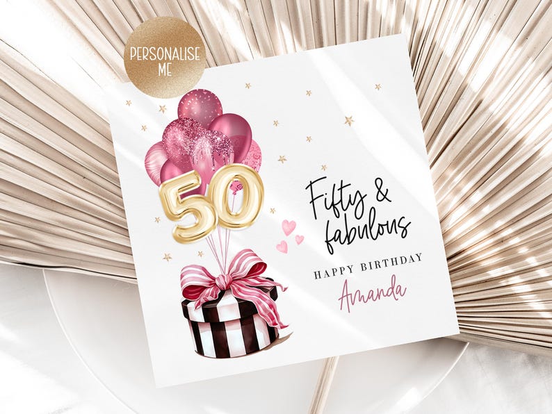 Puede incluir: Tarjeta de cumplea&ntilde;os con el texto "Fifty & fabulous" y "Happy Birthday Amanda". La tarjeta presenta una caja de regalo con un lazo rosa, globos y el n&uacute;mero "50" en dorado. Corazones rosas y estrellas doradas decoran la tarjeta.