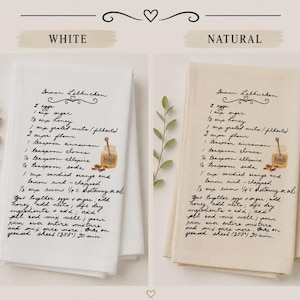 May include: Two folded kitchen towels, one white and one natural beige, each printed with a black cursive German Lebkuchen recipe. The text includes ingredients like eggs, sugar, honey, nuts, flour, spices, and instructions, accompanied by a small honey jar illustration.