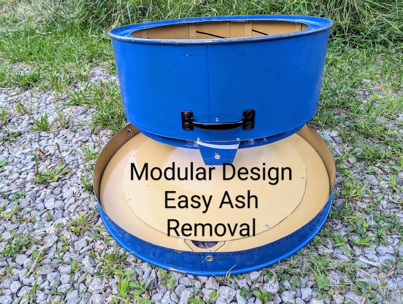 Puede incluir: Un componente de brasero de metal azul con un asa negra y una base circular color canela. El texto Modular Design Easy Ash Removal est&aacute; impreso en la base. La estructura presenta una secci&oacute;n superior cil&iacute;ndrica y una bandeja inferior plana.