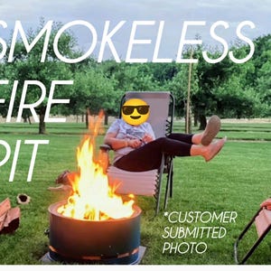 May include: A cylindrical metal smokeless fire pit with bright orange and yellow flames burning inside. The text SMOKELESS FIRE PIT and *CUSTOMER SUBMITTED PHOTO are overlaid on the image, which shows a grassy outdoor setting with chairs.