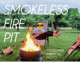 Puede incluir: Una hoguera cilíndrica de metal sin humo con llamas brillantes de color naranja y amarillo en su interior. El texto SMOKELESS FIRE PIT y *CUSTOMER SUBMITTED PHOTO se superpone a la imagen, que muestra un entorno exterior con césped.