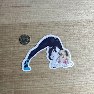 Peut inclure: Un autocollant représentant une illustration de style bande dessinée d'un personnage en costume noir et blanc, se penchant. Le personnage a les cheveux blonds avec des reflets roses et des accents bleus sur les chaussures. Une pièce est à côté de l'autocollant.