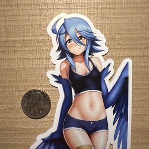 Peut inclure: Un autocollant représentant un personnage d'anime avec des cheveux bleus et des ailes. Elle porte une tenue bleue et noire et a une expression amicale.