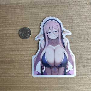 Peut inclure: Un autocollant représentant un personnage d'anime avec des cheveux roses, des yeux bleus et un haut de bikini bleu. Le personnage a des oreilles pointues et porte une coiffe de femme de chambre blanche.