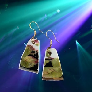 China earrings with green leaves on black and white background. Broken china earrings